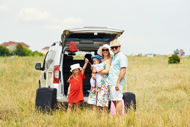 Vacanze, viaggi - famiglia felice pronta per il viaggio per le vacanze estive. Le persone si divertono e scattano foto al telefono. Scatta un selfie nel ricordo del viaggio