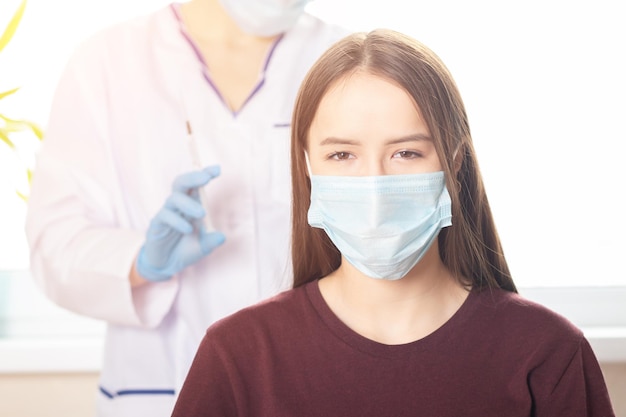 Vaccinazione Covid19 degli adolescenti un'infermiera inietta un vaccino contro il coronavirus a un'adolescente