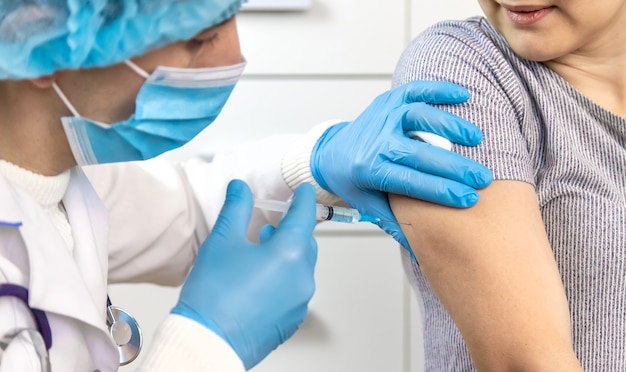 Vaccinazione di persone. Iniezione a mano. Persone di messa a fuoco selettiva