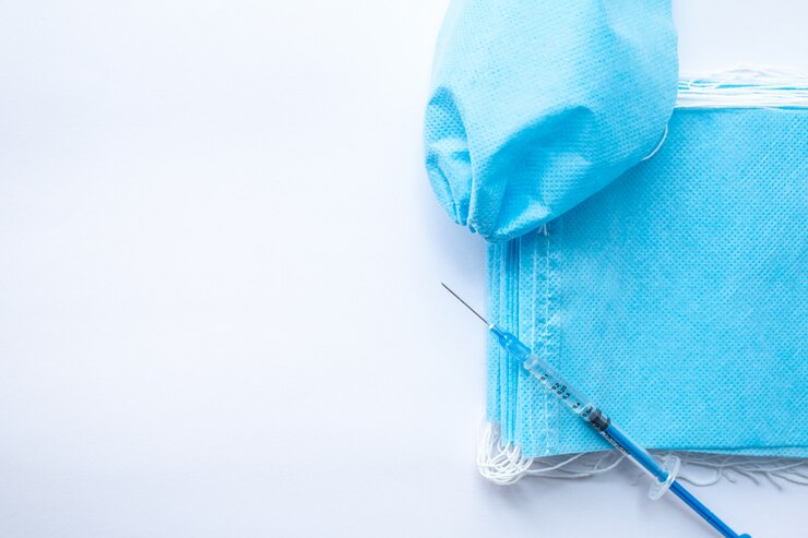 Vaccine and face mask on white wall