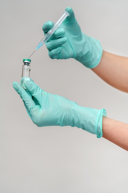 Vaccino e siringa femminili della tenuta di medico