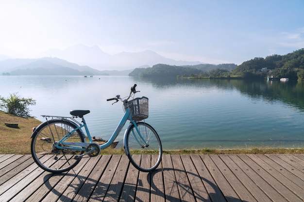 Vada in bicicletta sul ponte di legno con la bella vista di mattina