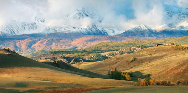 Valle con vista autunnale e montagne innevate