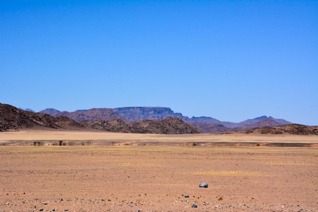 Valle del deserto senz'acqua all'orizzonte sullo sfondo del cielo blu Cambiamento climatico mondiale