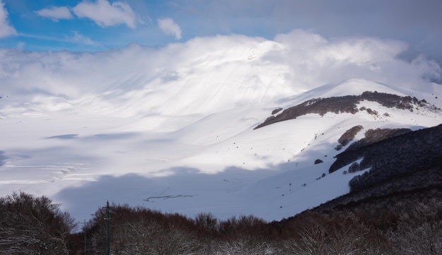Valle del paesaggio invernale e colline ricoperte di neve in una luminosa giornata di sole
