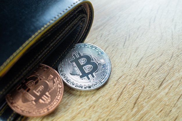 Valuta digitale Bitcoin con portafoglio in pelle o borsa in legno