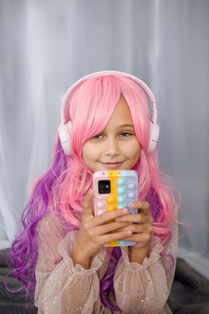 Vanilla Girl Kawaii vibes Piccola ragazza con i capelli rosa fa una festa in stile barbie Ascolta musica con le cuffie telefono cellulare