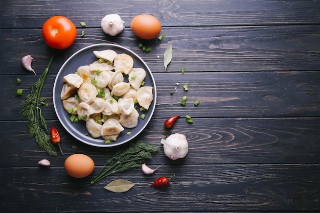 Vareniki con patate e cipolle su un piatto scuro con spazio per testo