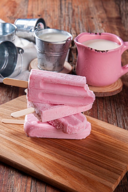 Vari ghiaccioli allo yogurt con fragola. Uno di loro è stato morso, manca un pezzo. Copia spazio.