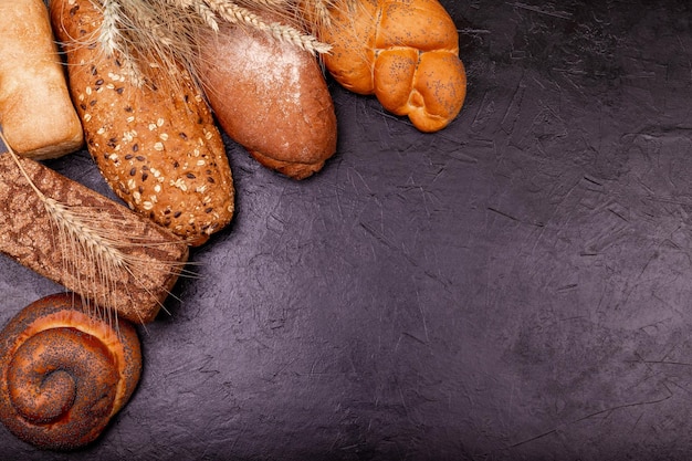 Vari gustosi panini e pane con grano si chiudono su sfondo grigio