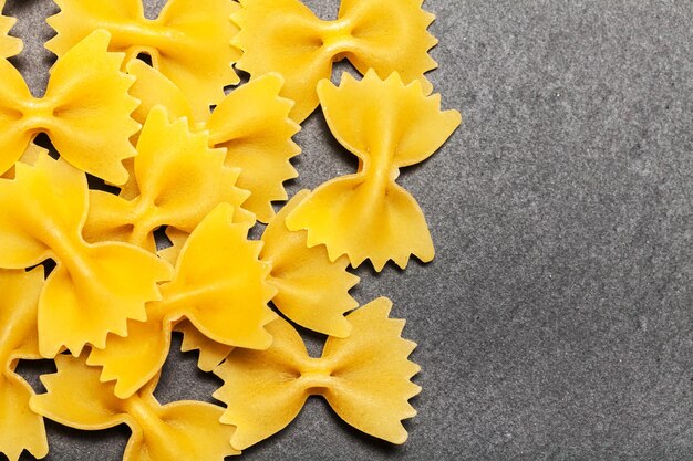 Vari mix di pasta su fondo rustico in legno sacco e cucchiai di legno Dieta e concetto di cibo