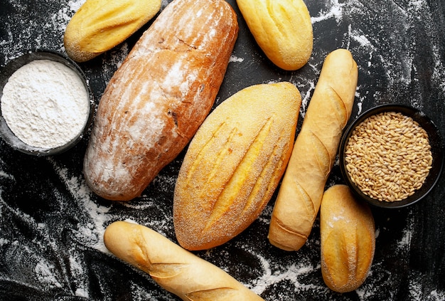 Vari pane e panini freschi su una tavola di pietra.