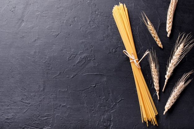 Vari pasta e grano su uno sfondo di pietra nera. Vista dall'alto con copia spazio.