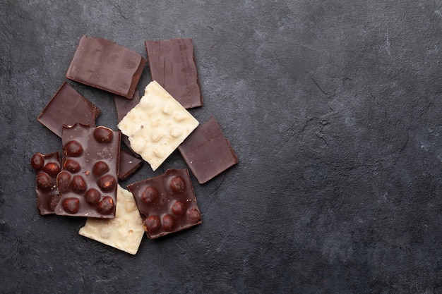 Vari pezzi di cioccolato su tavolo in pietra Vista dall'alto distesa piatta con spazio per la copia