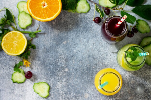 Vari rinfreschi bevande detox acqua di cetriolo succo di ciliegia e succo d'arancia Vista dall'alto