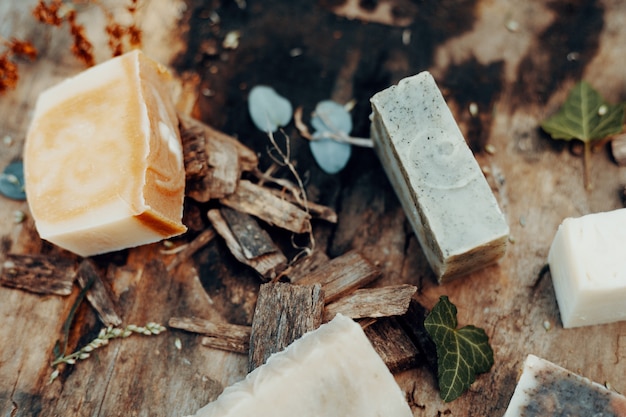 Vari saponi naturali fatti a mano su un tavolo in legno vintage con decorazioni