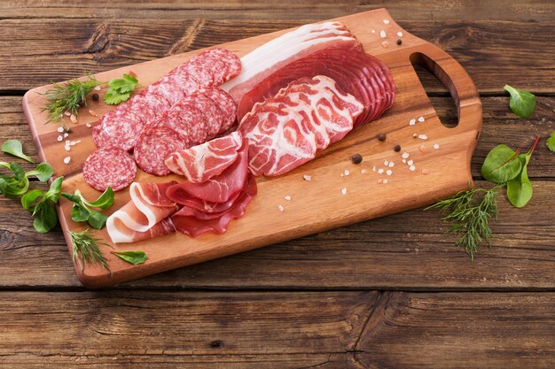 Vari tipi di carne e salsiccie sulla tavola di legno