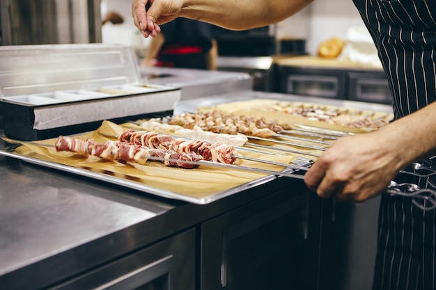 Vari tipi di carne su spiedini per friggere shish kebab alla griglia nella cucina del ristorante