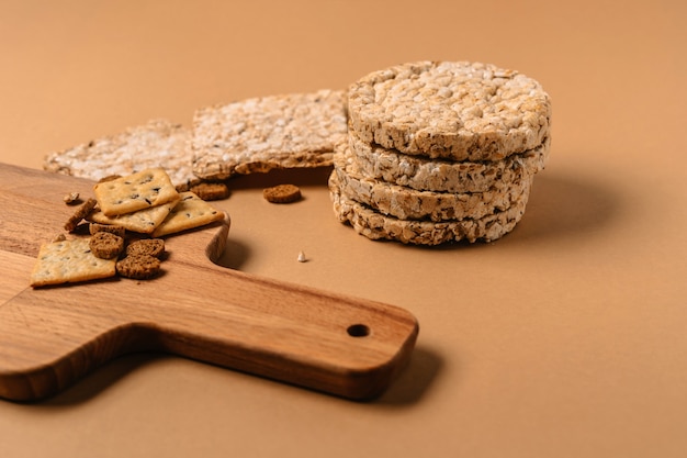 Vari tipi di fette biscottate e biscotti integrali sani sulla parete marrone su una tavola di legno