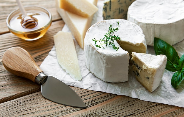 Vari tipi di formaggio, gorgonzola, brezza, camambert su un tavolo di legno