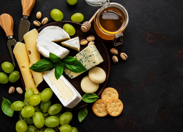 Vari tipi di formaggio su un tavolo di cemento nero