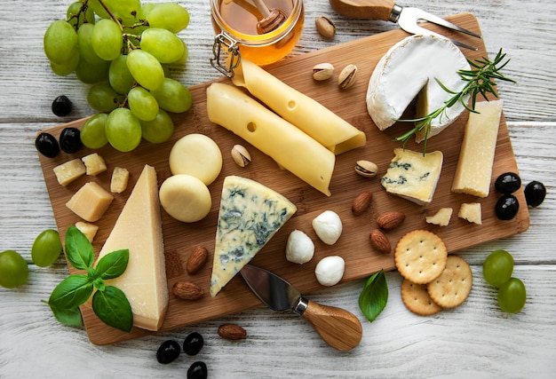 Vari tipi di formaggio su una tavola di legno bianca