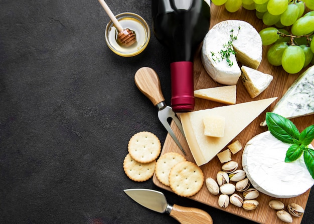 Vari tipi di formaggio, uva e vino su un nero