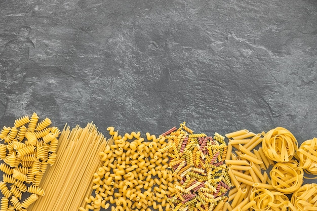 Vari tipi di pasta su fondo scuro dall'alto