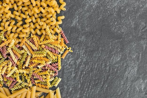 Vari tipi di pasta su fondo scuro dall'alto