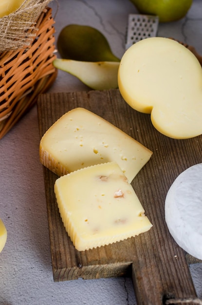 Vari tipi di teste e pezzi di formaggio su una tavola di legno