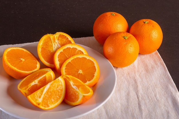 Varias naranjas cortadas en un plato blanco, vista cerrada, vista cercana de fruta fresca