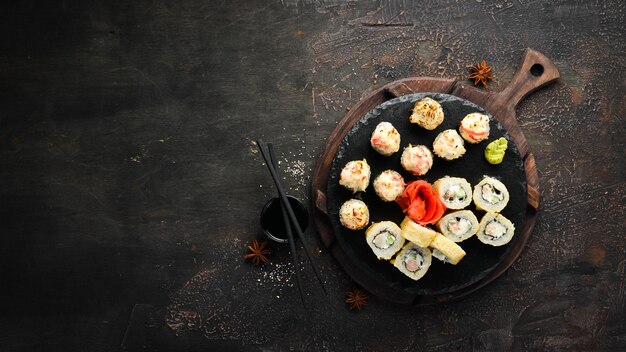 Variazione di sushi e panini su un piatto. Vista dall'alto. Spazio libero per il tuo testo. Su uno sfondo scuro.