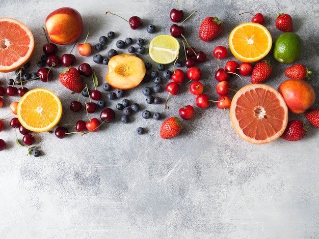 Varie bacche e frutti su uno sfondo grigio