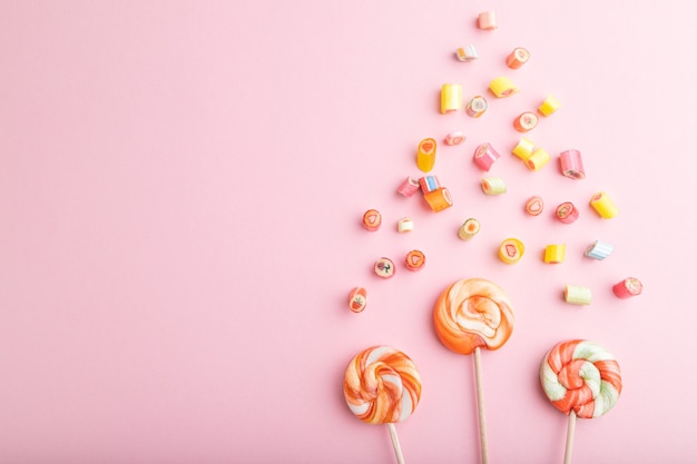 Varie caramelle al caramello su pastello rosa