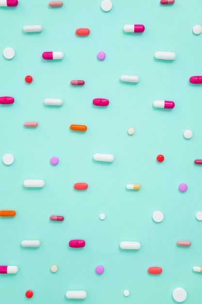 Varie compresse e capsule di farmaci bianchi su sfondo verde Concetto di assistenza sanitaria e medicina