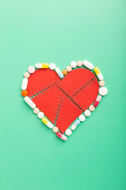 Varie compresse e capsule farmaceutiche per il trattamento delle malattie cardiache Forma del cuore e una bottiglia di pillole Copia spazio per il testo