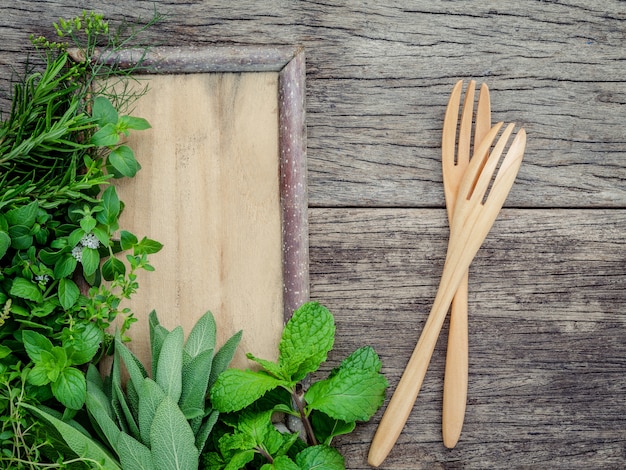 Varie erbe aromatiche e spezie installate su fondo di legno.