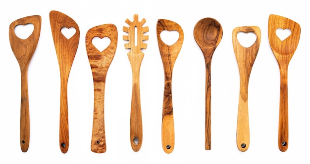 Varie forme di cuore di utensili da cucina in legno cucchiai di legno e spatola di legno isolare su sfondo bianco