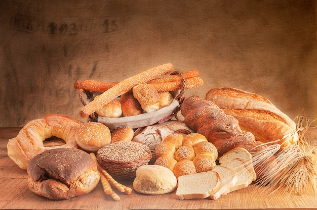 Varie forme di pane appena sfornato su una tavola di legno crosta di pane