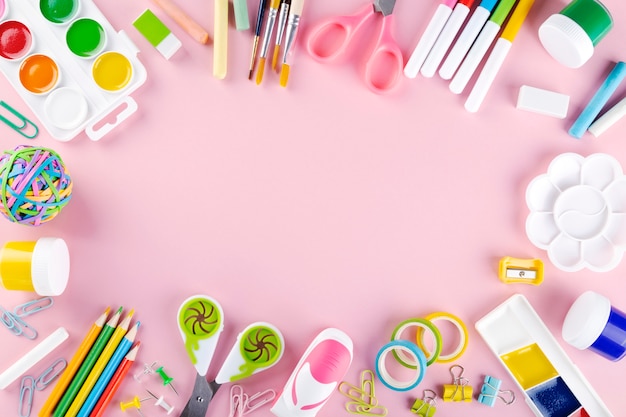 Varie forniture di scuola e pittura su sfondo rosa. Torna al concetto di scuola. Vista dall'alto. Copia spazio