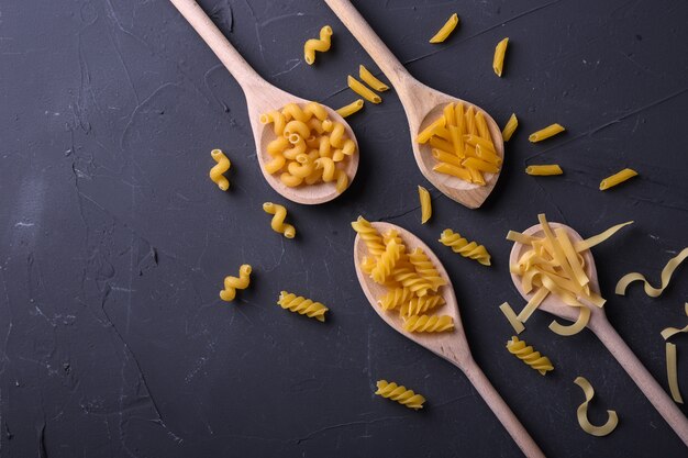 Varie pasta su cucchiai. Vista dall'alto con spazio di copia