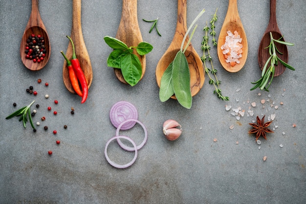 Varie spezie ed erbe aromatiche in cucchiai di legno.