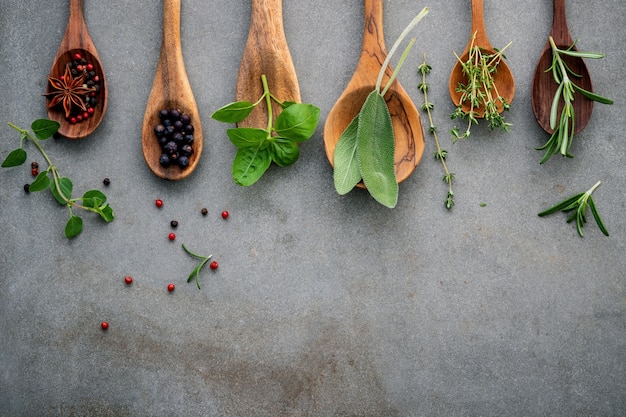 Varie spezie ed erbe aromatiche in cucchiai di legno.