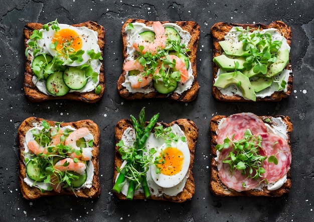 Varietà colazione antipasto tapas pane integrale panini con crema di formaggio uovo asparagi avocado cetriolo gamberetti salame