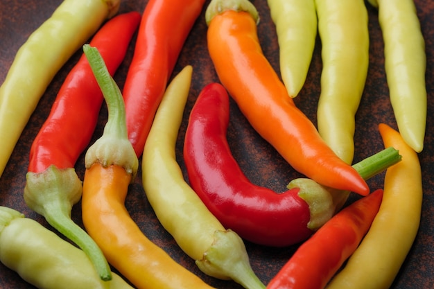 Varietà da interni peperoncino amaro caldo multicolore su una macrofotografia ravvicinata di un piatto di argilla marrone