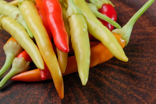 Varietà da interni peperoncino amaro caldo multicolore su una macrofotografia ravvicinata di un piatto di argilla marrone