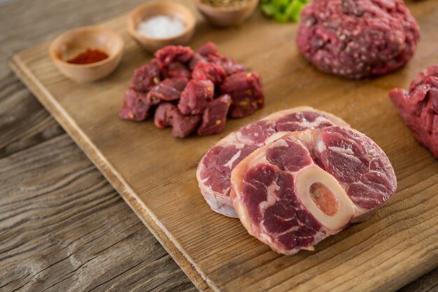 Varietà di carne e spezie sul vassoio di legno