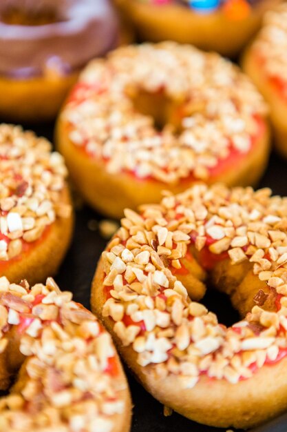 Varietà di ciambelle fresche con diversi condimenti dal panificio locale.