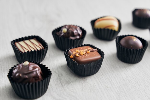 Varietà di deliziose caramelle di cioccolato su fondo di legno