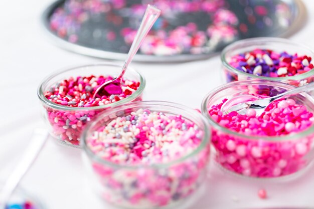 Varietà di granelli rosa per decorare i biscotti di San Valentino.